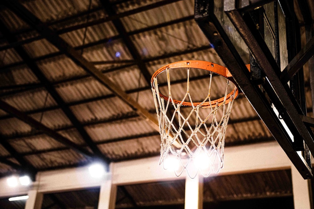 a basketball hoop hanging from the ceiling of a basketball court