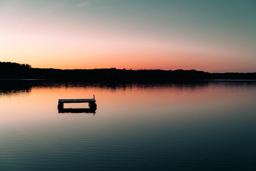 a bench sitting in the middle of a lake