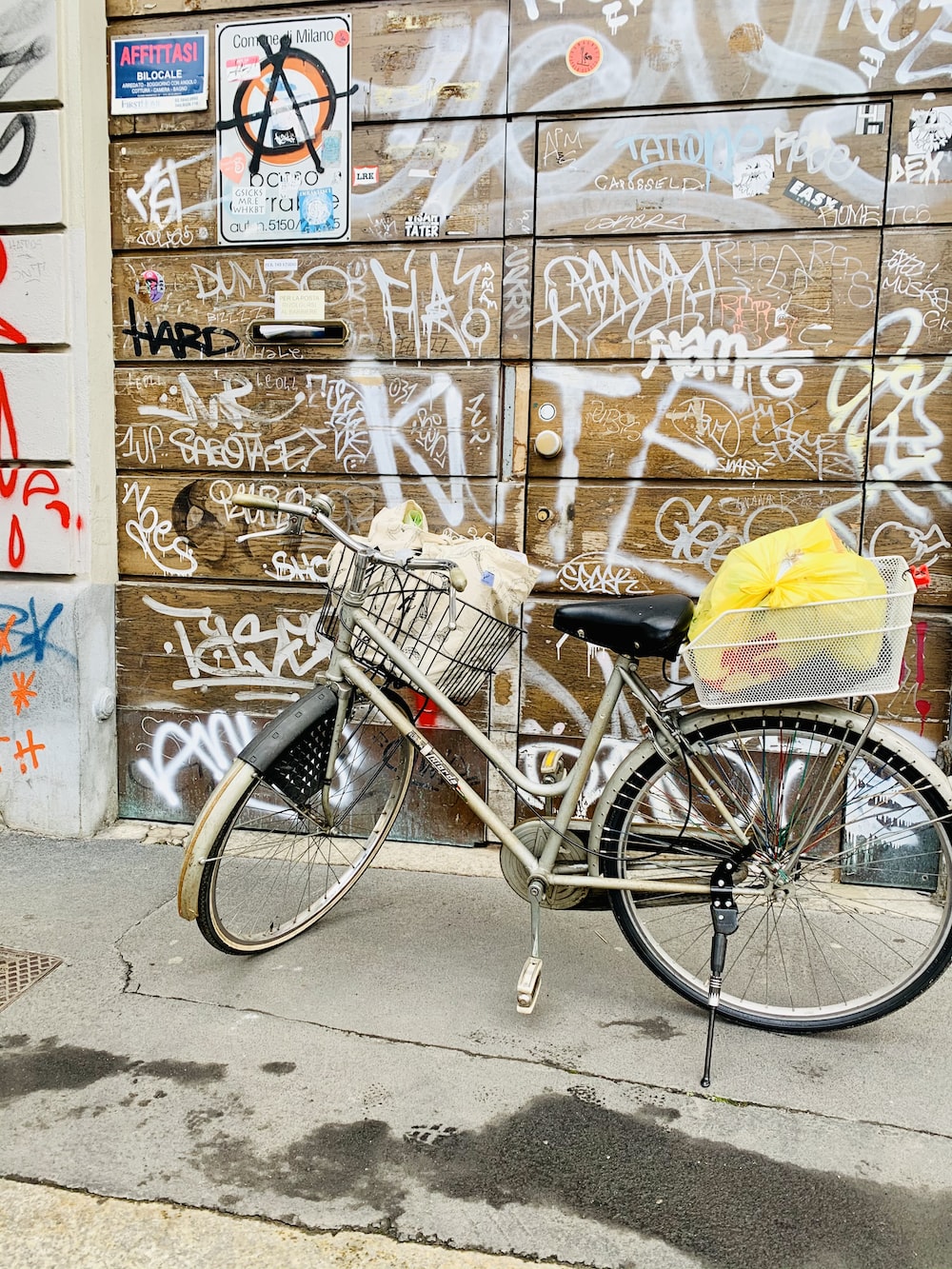 a bicycle parked in front of a wall covered in graffiti