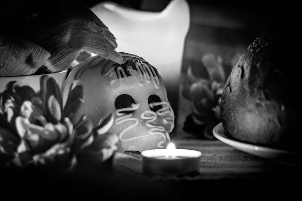 a black and white photo of a candle and a skull