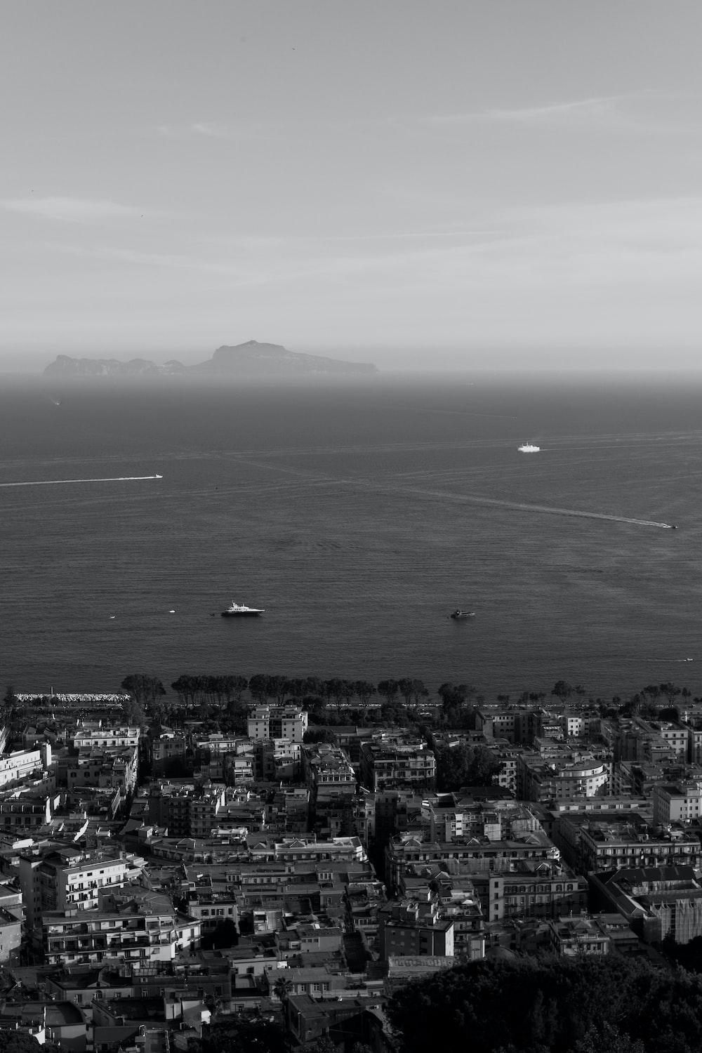 a black and white photo of a city by the ocean