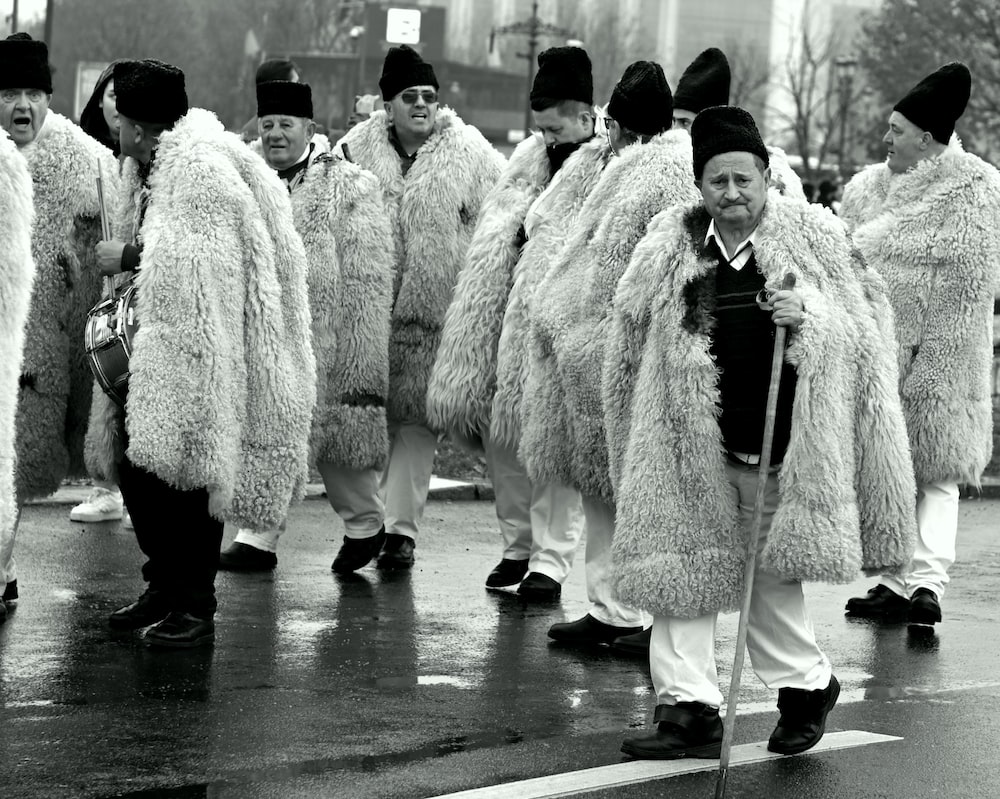 a black and white photo of a group of people in furry coats