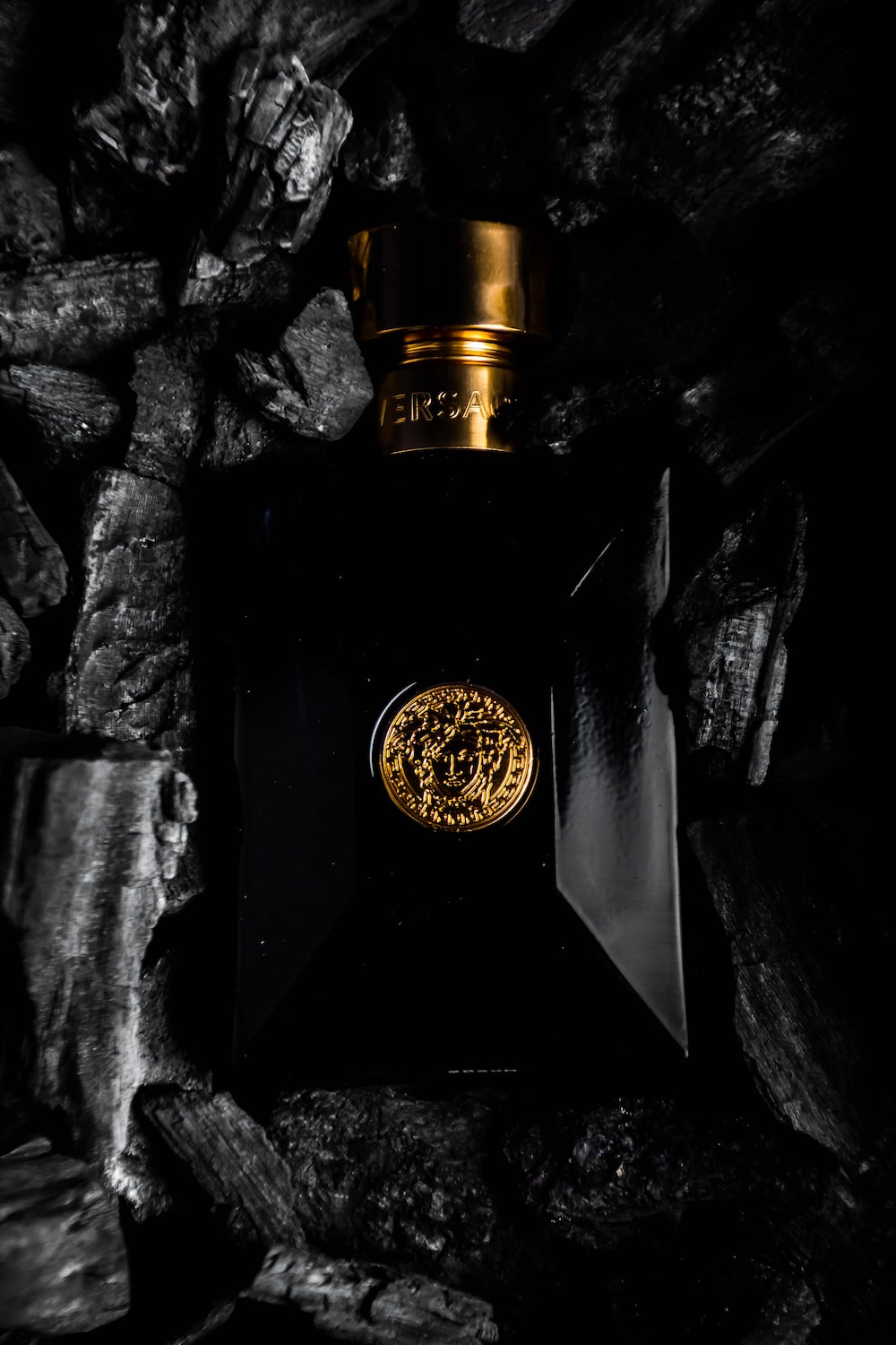 a black bottle with a gold emblem on it