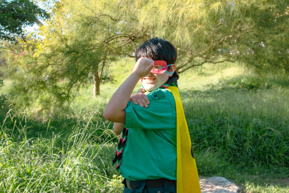 a boy in a green shirt and yellow scarf