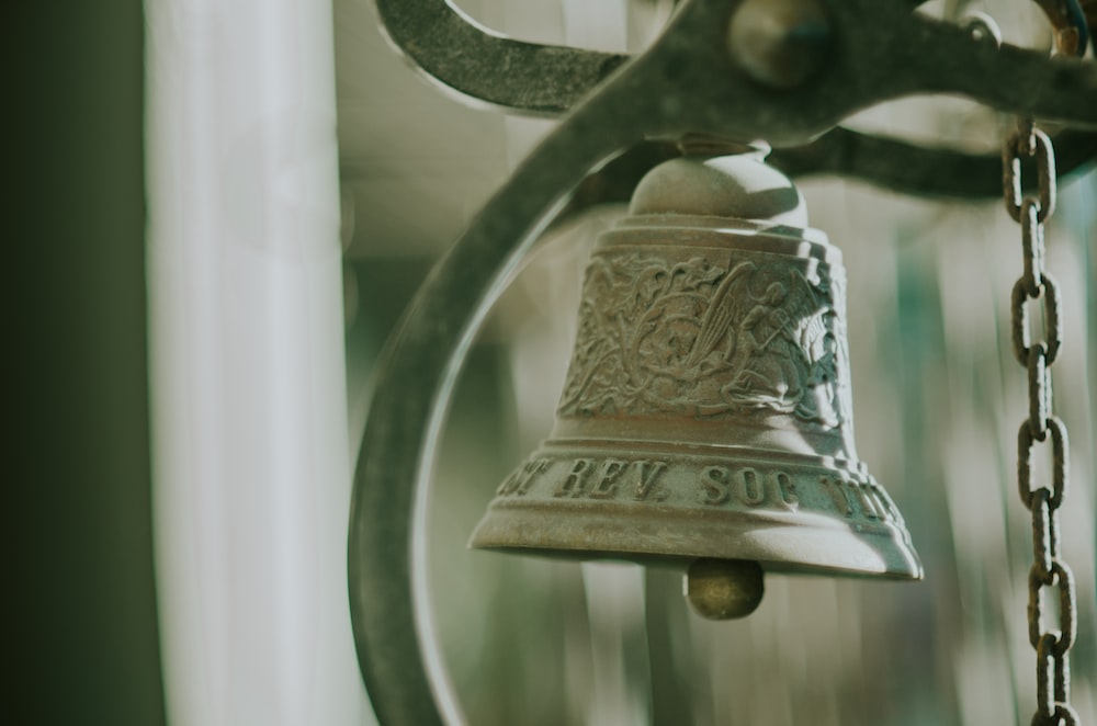 a close up of a bell on a chain