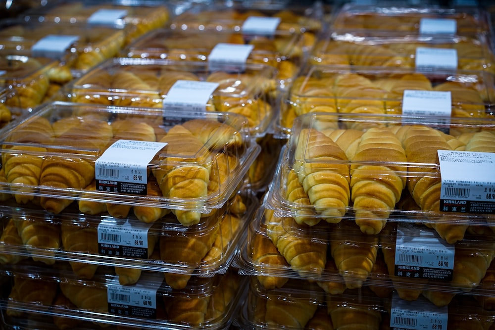 a close up of many pastries in plastic containers