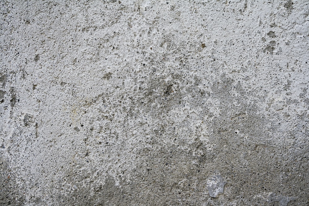 a concrete wall with a small patch of dirt on it