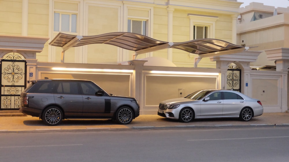 a couple of cars parked in front of a building with a large archway