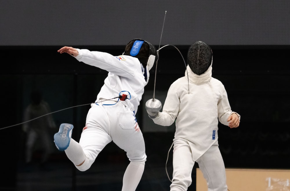 a couple of people in white fencing suits