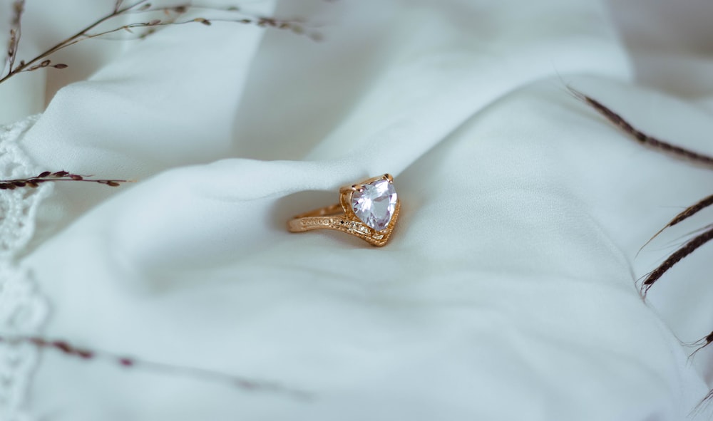 a diamond ring sitting on a white cloth