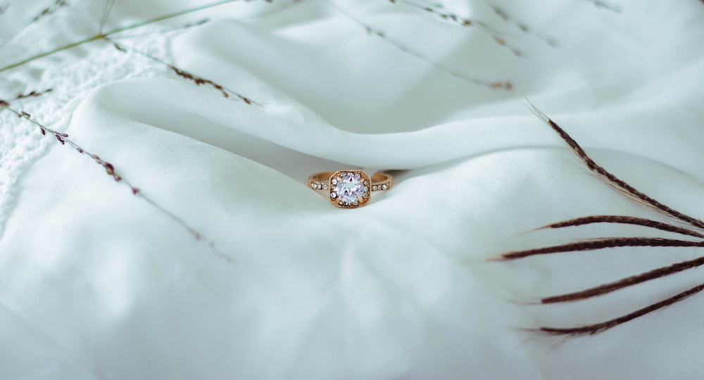 a diamond ring sitting on top of a white cloth