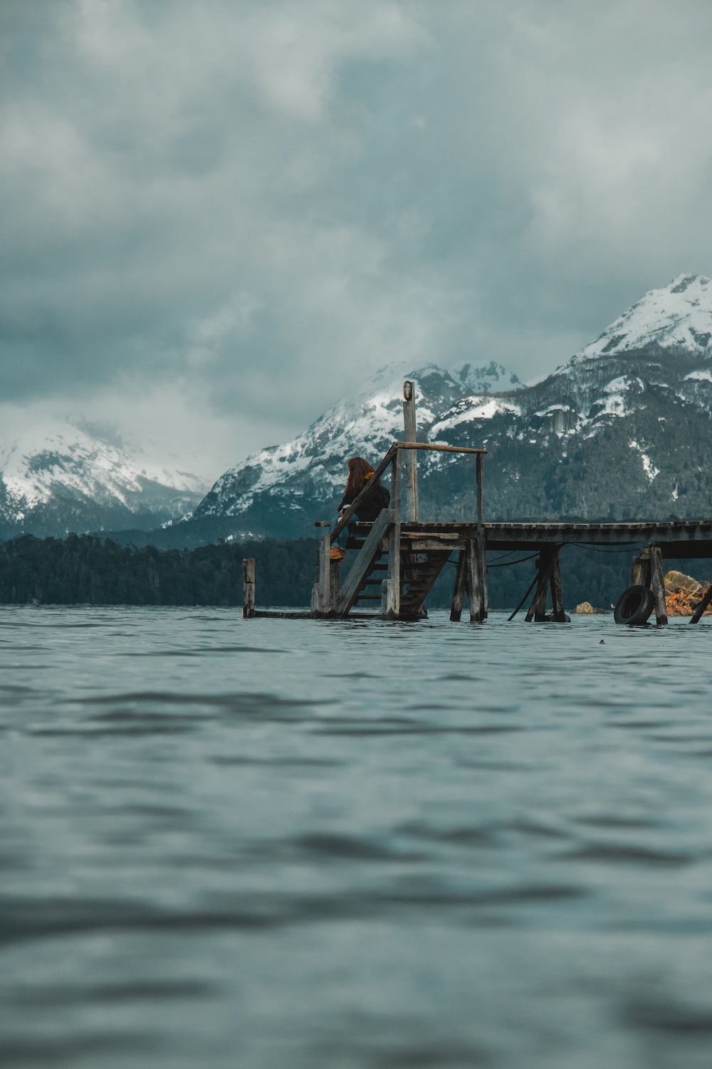 a dock in the water with mountains in the background