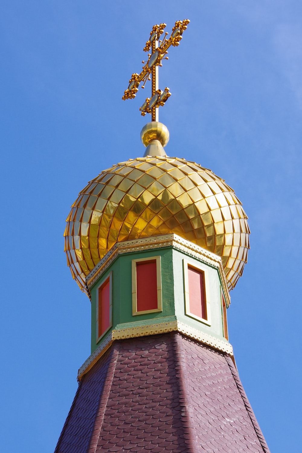 a gold dome on top of a building with a cross on top