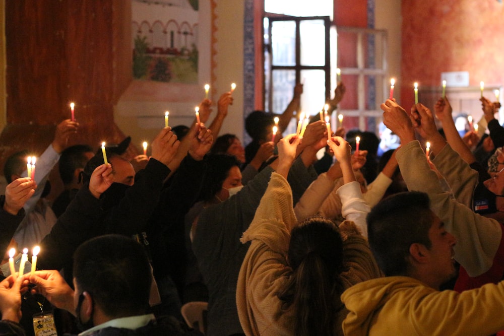 a group of people holding candles in the air