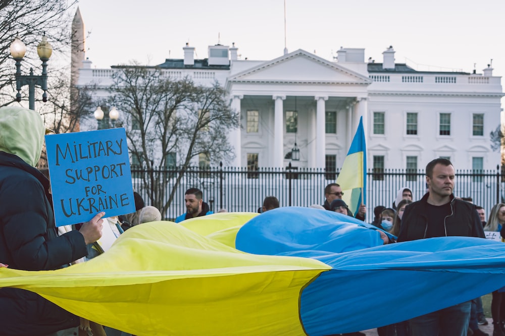 a group of people holding signs in front of a white house