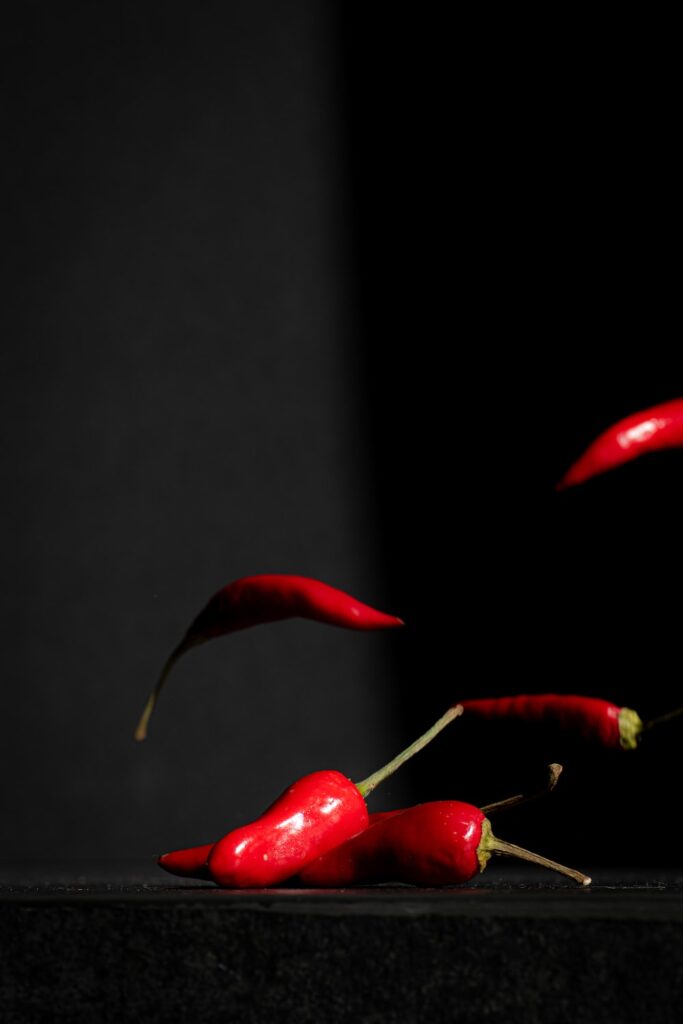 a group of red chili peppers on a black surface