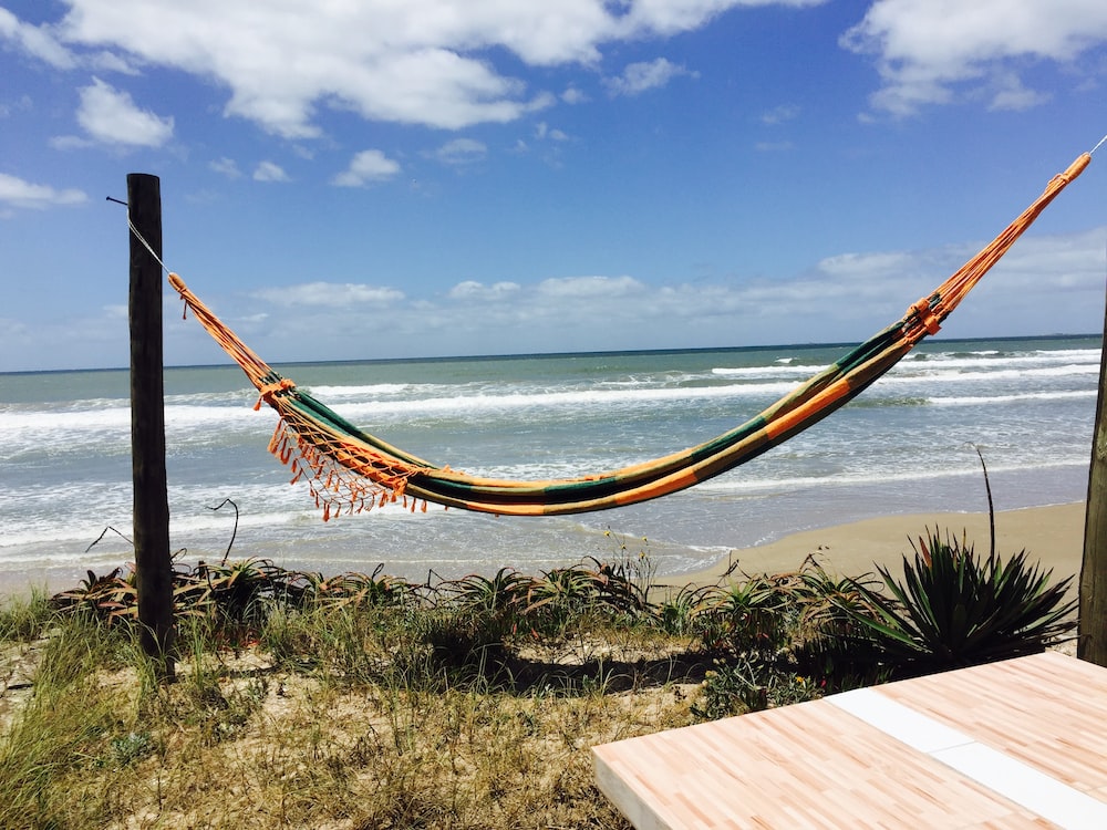 a hammock on the beach with a view of the ocean