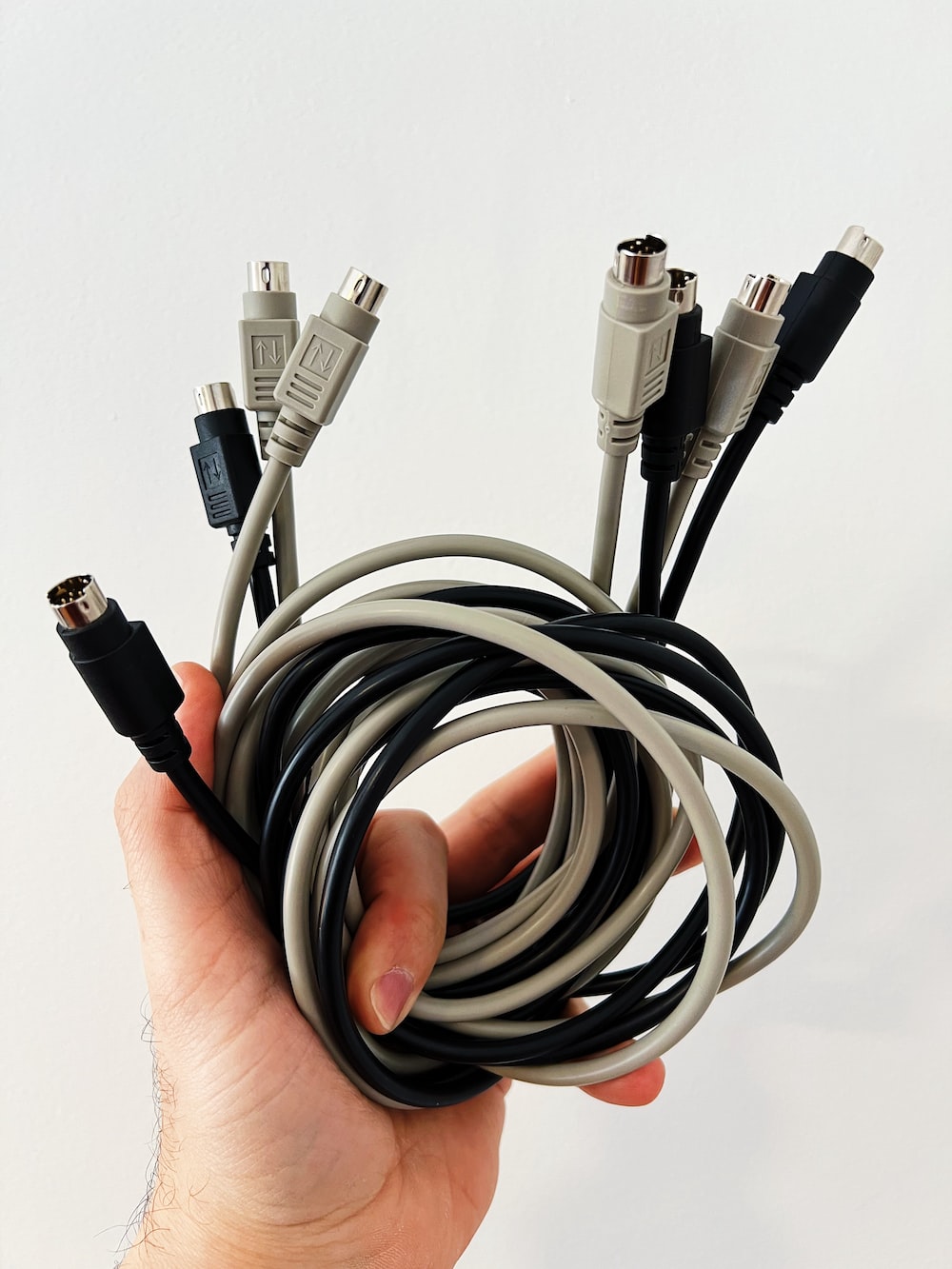 a hand holding a black and white cable