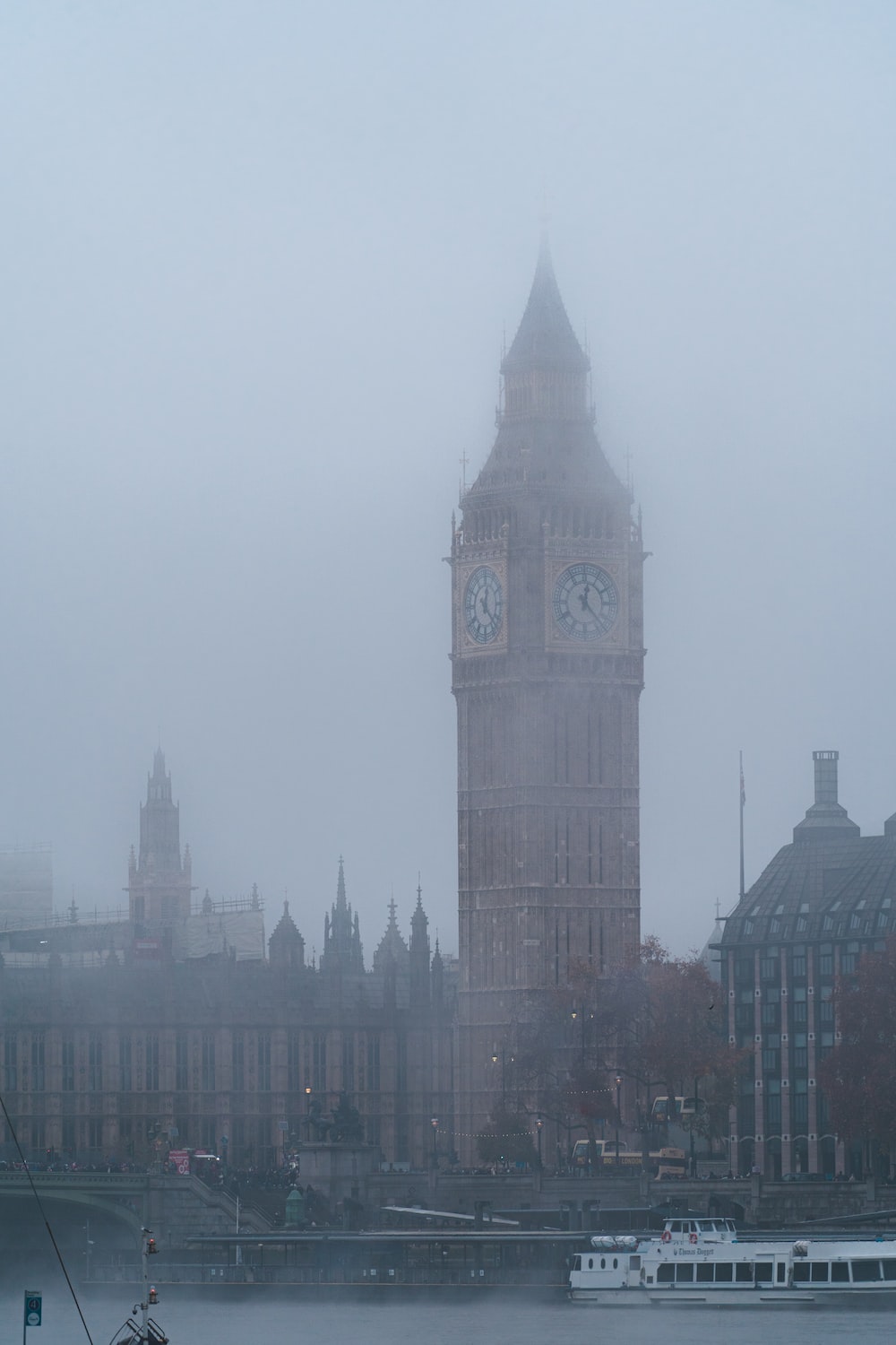 a large clock tower towering over a city on a foggy day