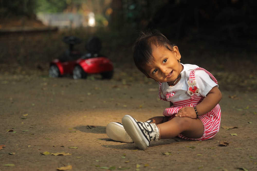 a little girl playing with a shoe