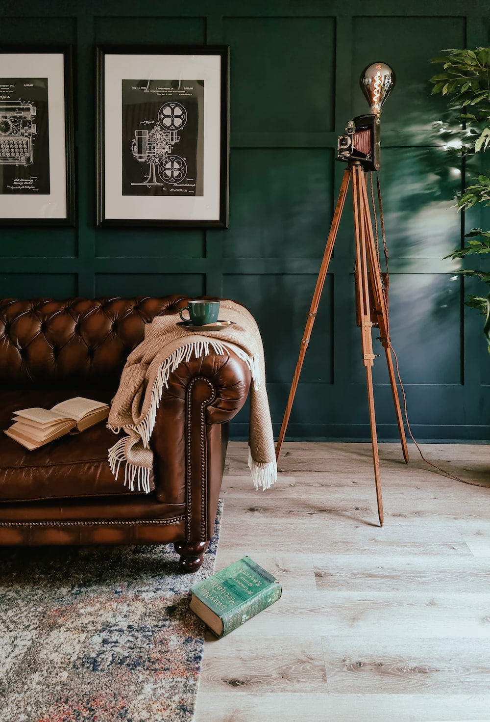 a living room with a leather couch and a tripod