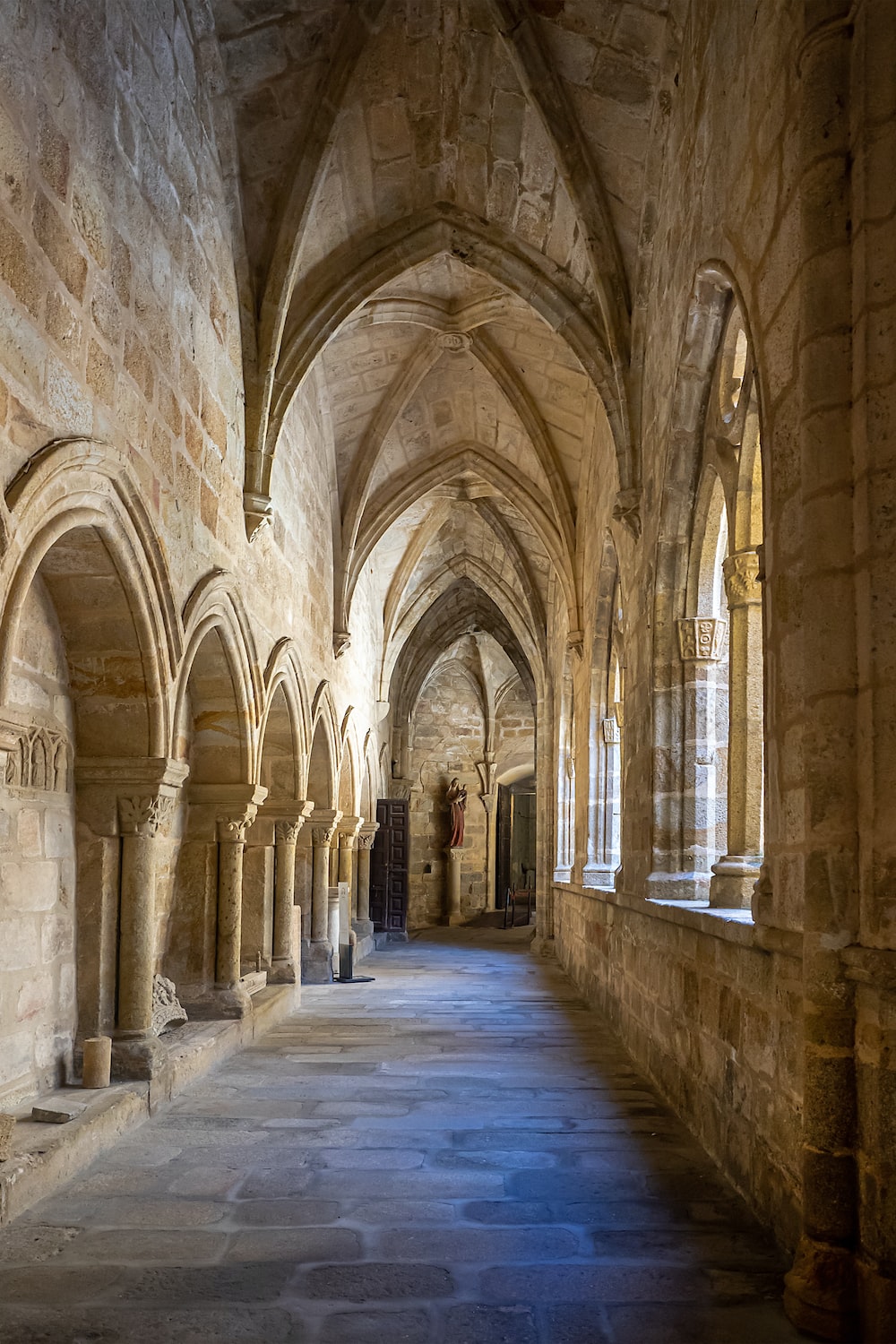 a long hallway with stone walls and arches