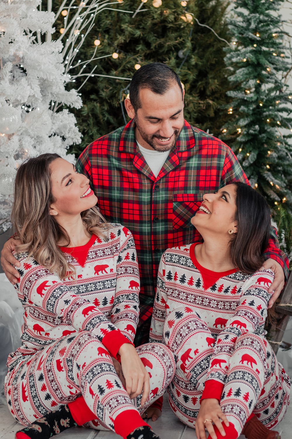 a man and a woman wearing matching christmas pajamas