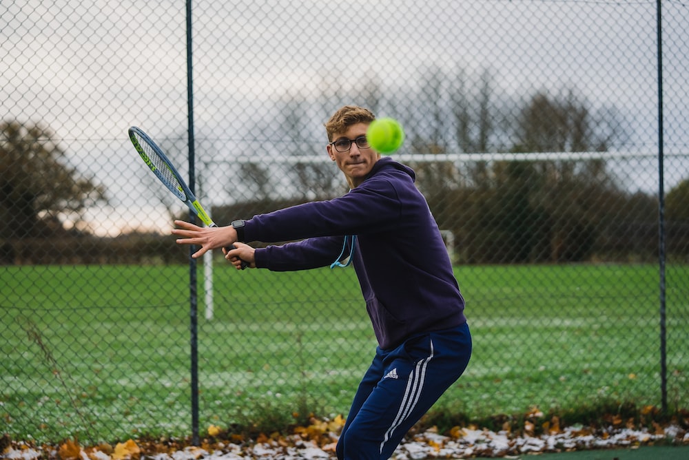 a man hitting a tennis ball with a tennis racquet