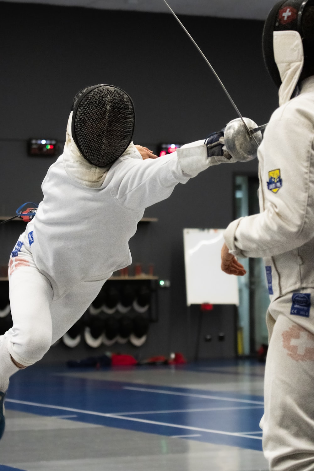 a man in a fencing suit is hitting a ball