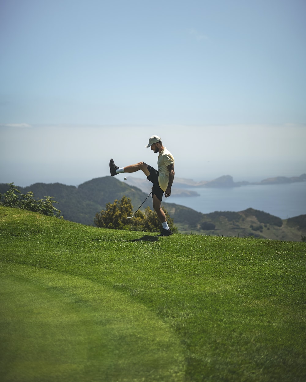 a man on a golf course kicking a ball