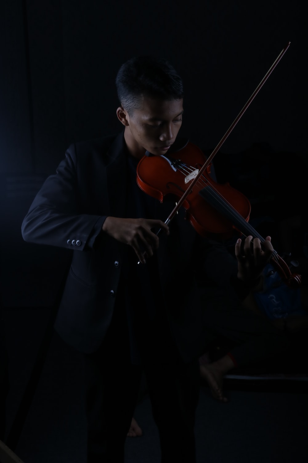a man playing a violin in the dark