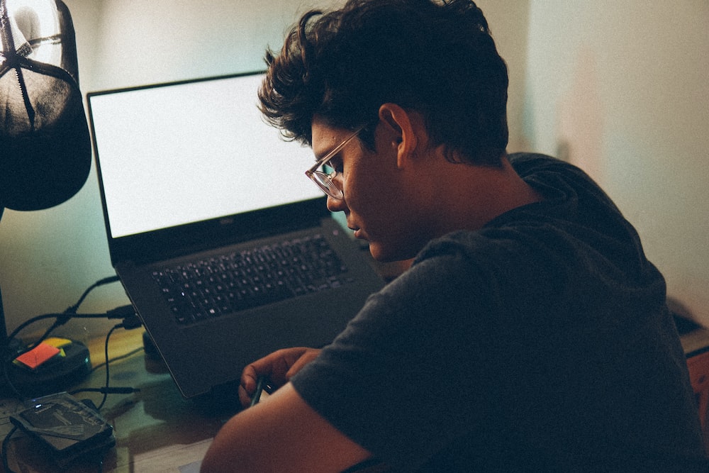 a man sitting in front of a laptop computer
