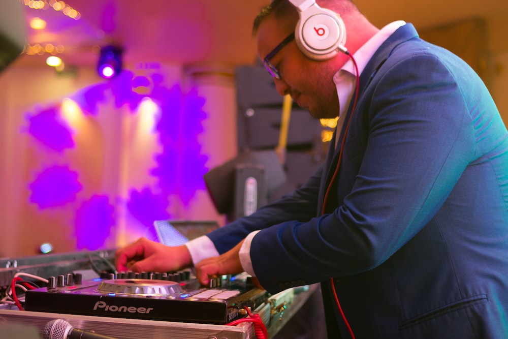 a man wearing headphones is playing a dj's turntable