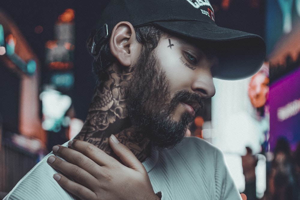 a man with a beard and tattoos on his neck