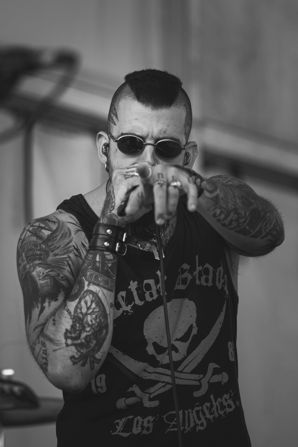 a man with tattoos on his arms holding a wine glass