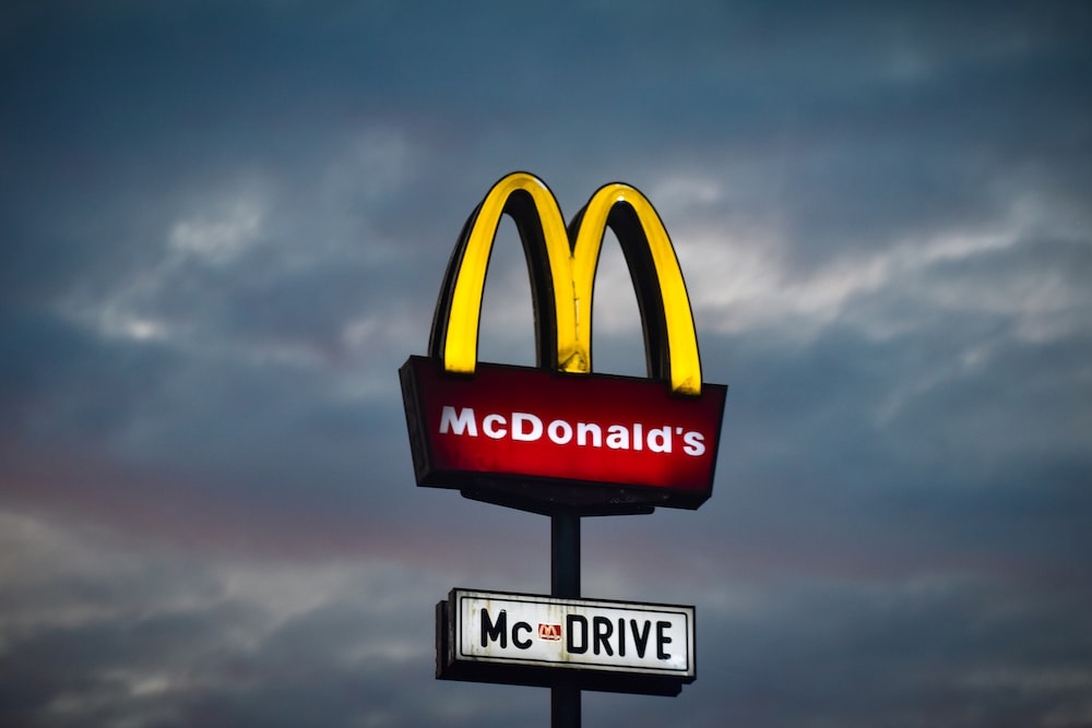 a mcdonald's sign with a cloudy sky in the background