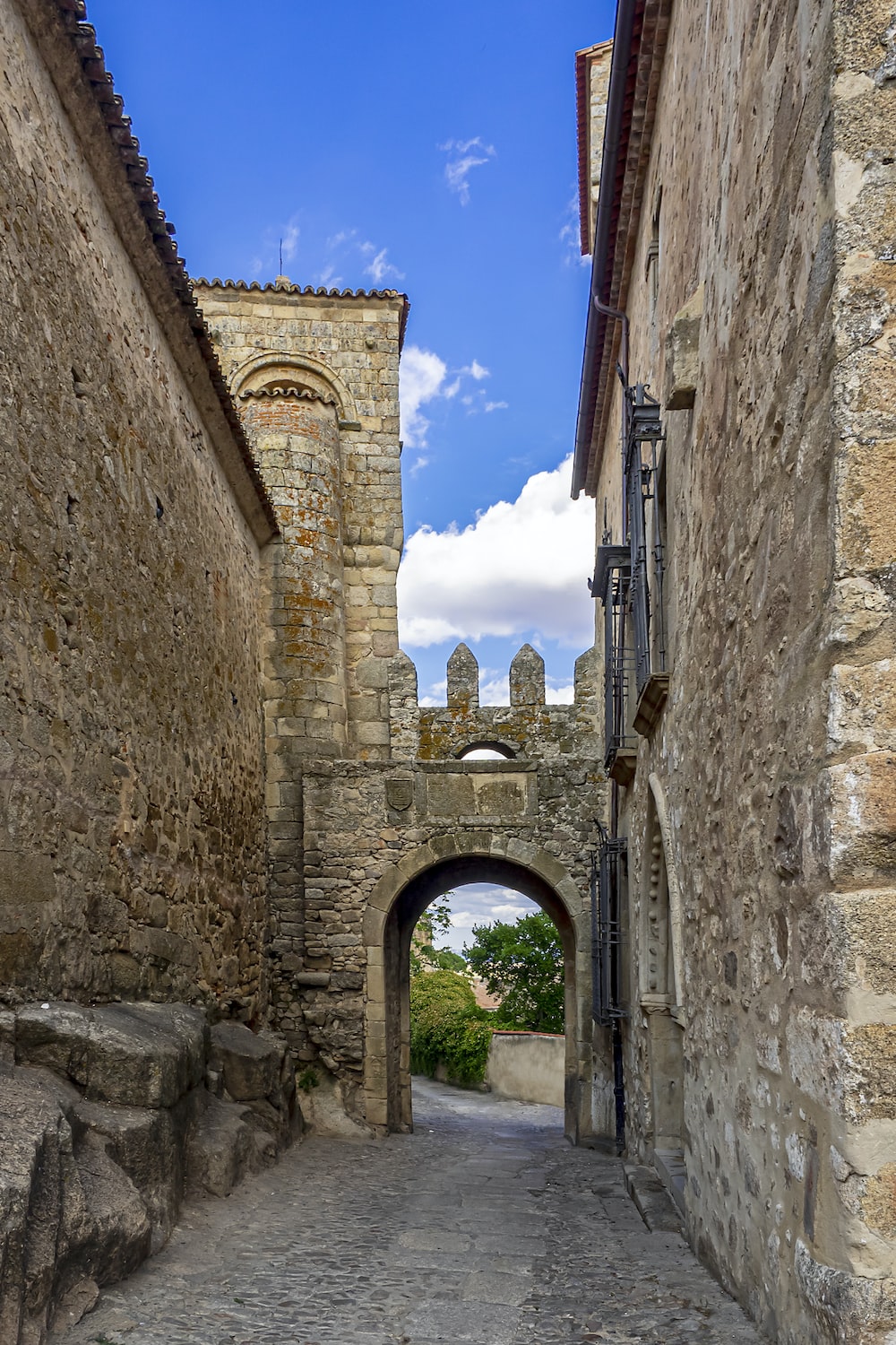 a narrow street with a stone archway between two buildings