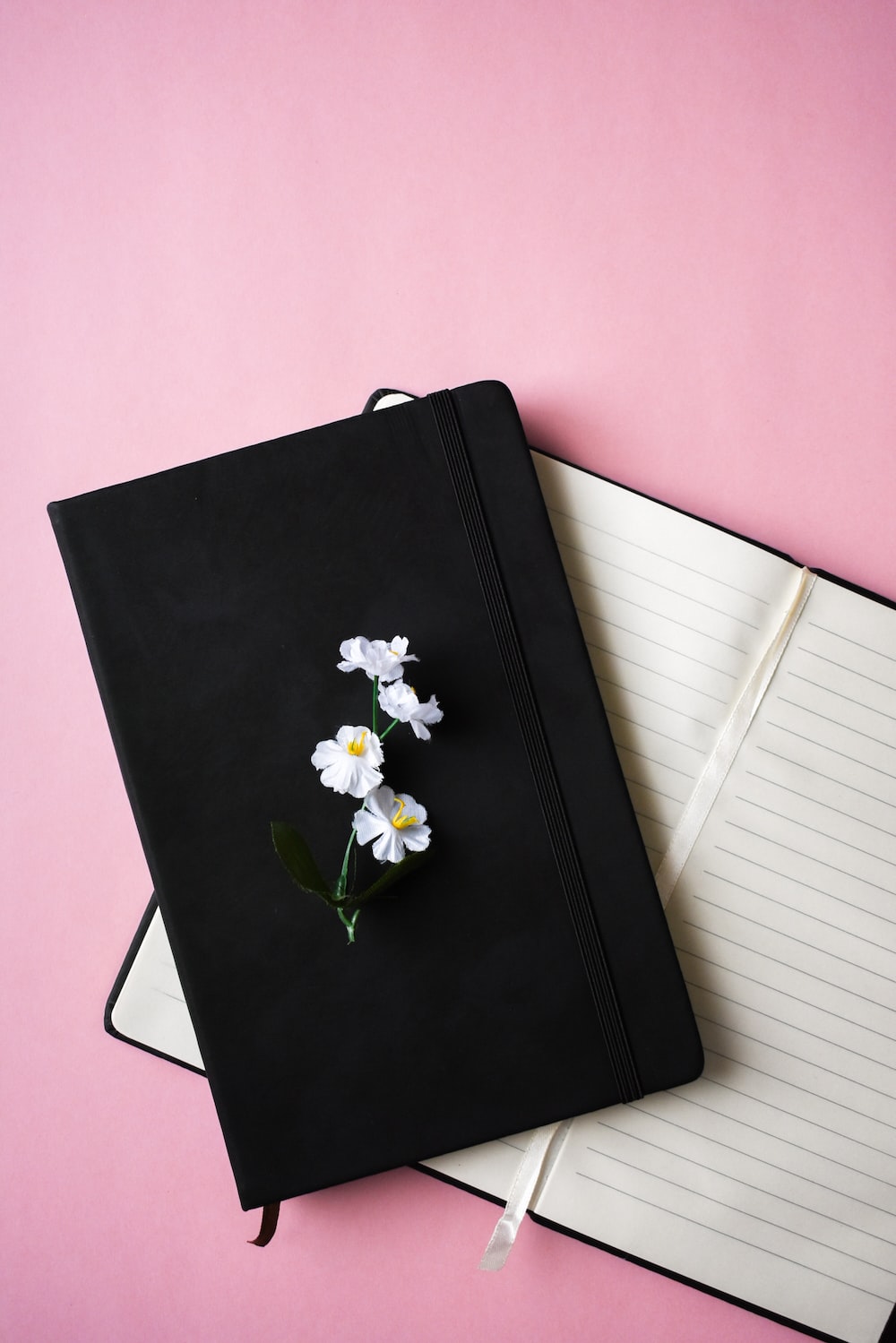 a notebook with a flower on top of it