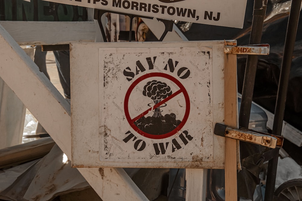 a no war sign posted on a street corner
