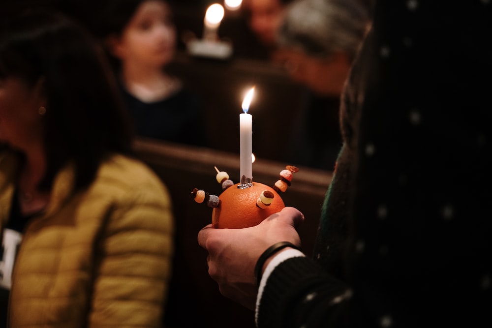a person holding a candle in their hand
