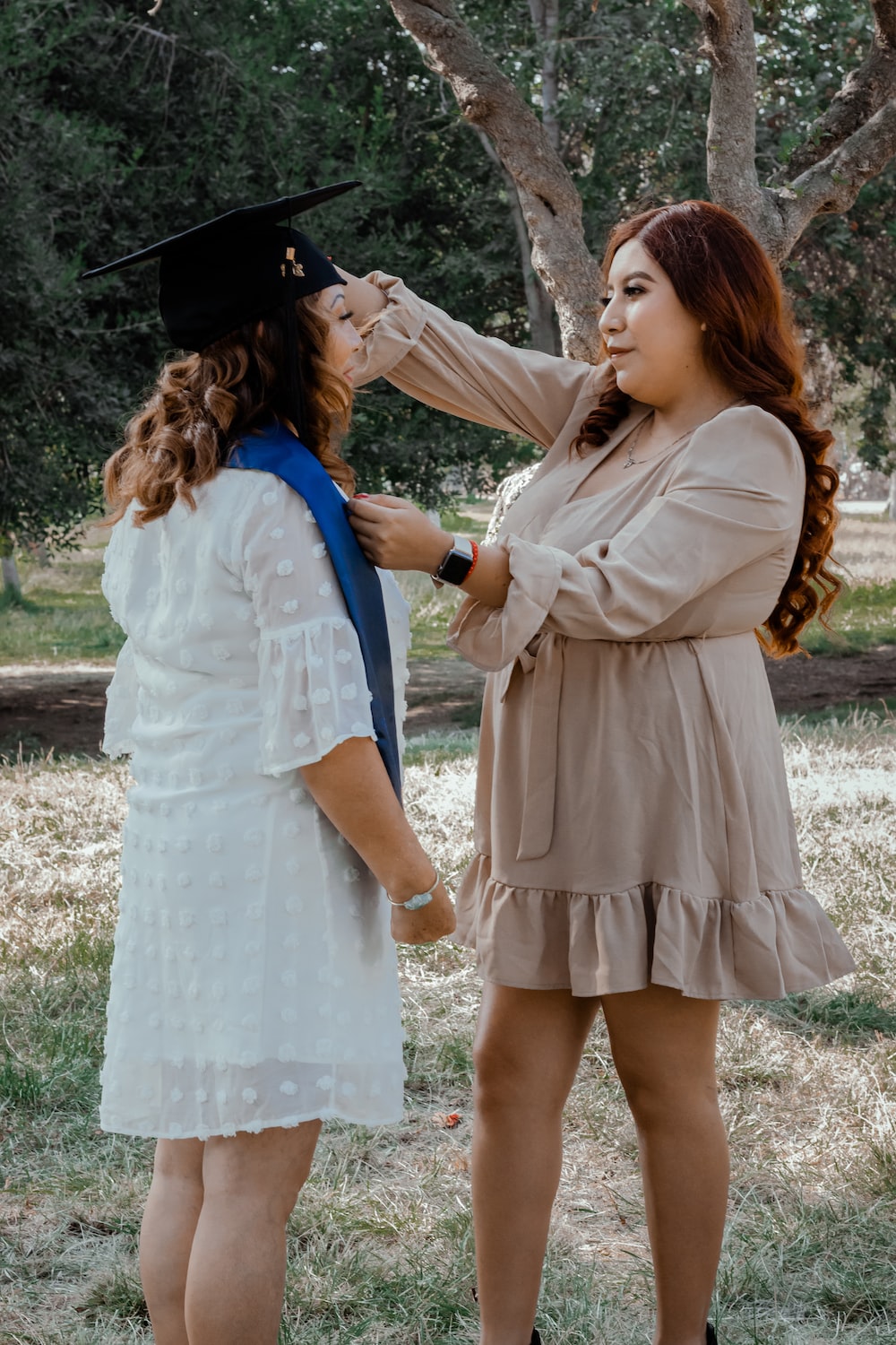 a person in a graduation gown and a person in a dress