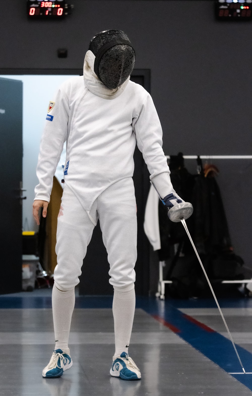 a person in a white suit with a stick