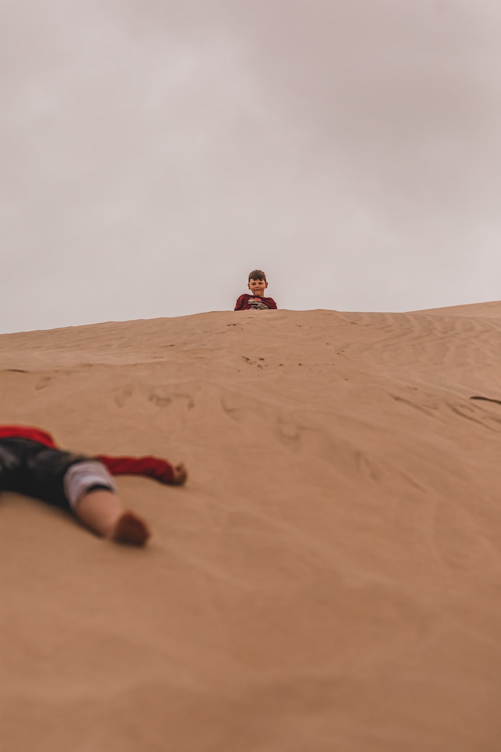 a person laying on top of a sandy hill