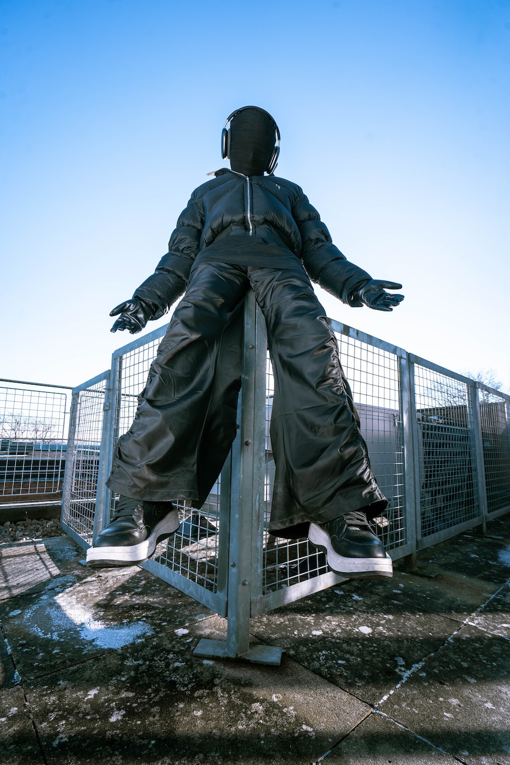 a person sitting on a fence with their arms outstretched