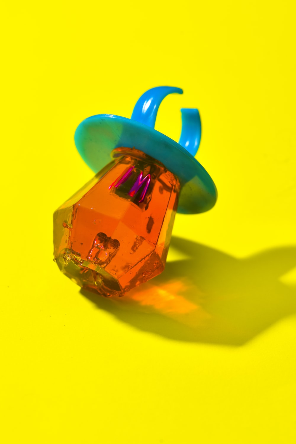 a plastic object sitting on top of a yellow surface
