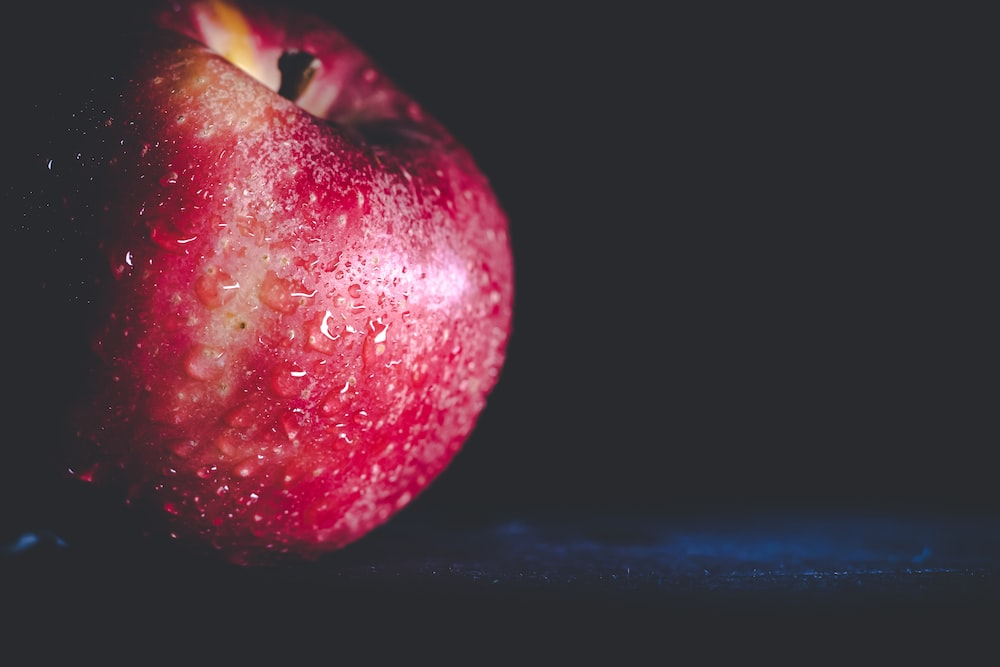 a red apple with a black background