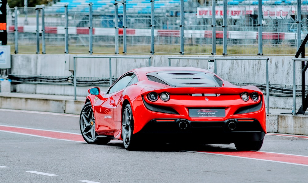 a red sports car driving down a race track