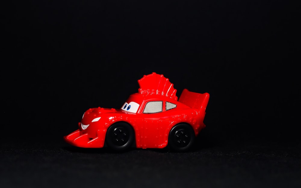a red toy car on a black background