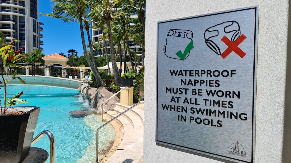 a sign on the side of a building near a pool