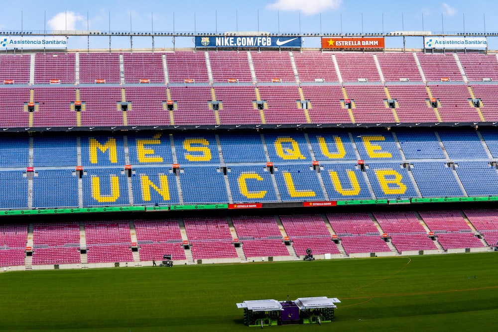 a sports stadium with a field and a field with Camp Nou in the background